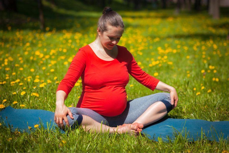 Peaceful young positive pregnant woman in gymnastic suit does yoga and  meditate sitting on mat on green grass on sunny warm summer day. Concept of  preparation for childbirth and positive attitude 16791340